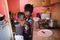 A mother and her son are together inside their home. They are in the kitchen. The mother and son are giving each other a hug. This is in Ghana, Africa.