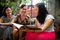 Three women in the Philippines sitting outside and reading from the Liahona together.